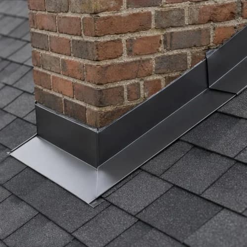 Roofer repairing chimney flashing on shingle roof